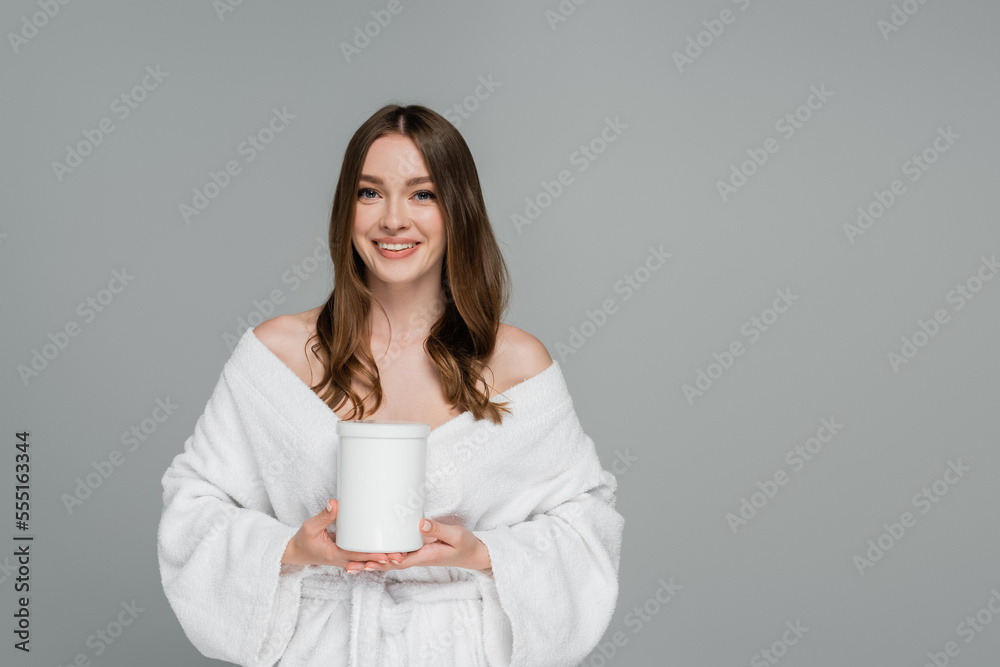 cheerful young woman with shiny hair holding container with treatment mask isolated on grey cheerful young woman with shiny hair holding container with treatment mask isolated on grey