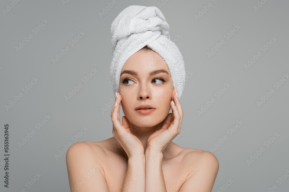 young woman with bare shoulders and towel on head looking away isolated on grey young woman with bare shoulders and towel on head looking away isolated on grey