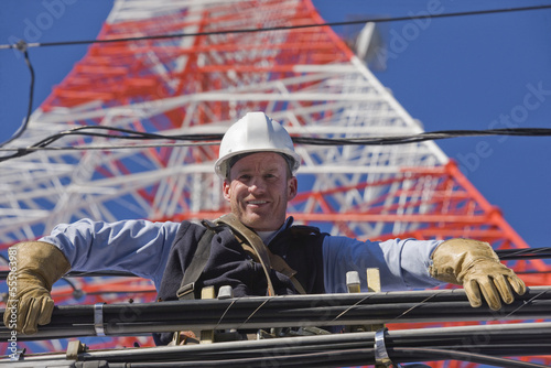 Low angle view of a cable lineman repairing transmission line photo