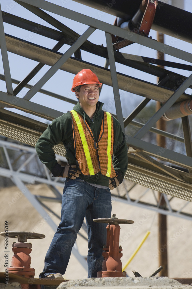 Engineer standing near control valves and smiling Engineer standing near control valves and smiling