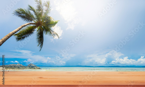 Top wood table and coconut palm tree and tropical beach background.Empty ready for your product display montage.