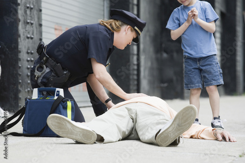 Wallpaper Mural Woman police officer administering first aid to a senior man Torontodigital.ca