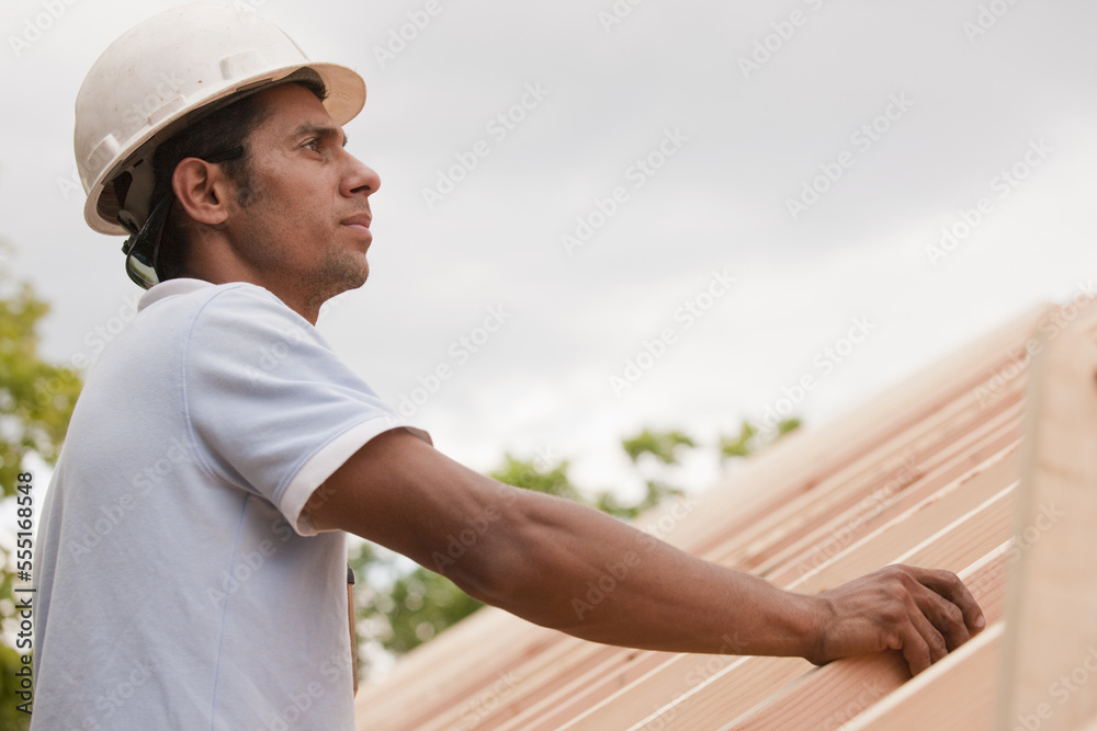 Carpenter examining roof framing Carpenter examining roof framing