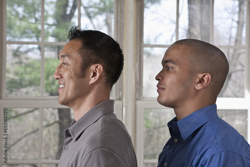 Portrait of the side view of two young businessmen standing facing left Portrait of the side view of two young businessmen standing facing left