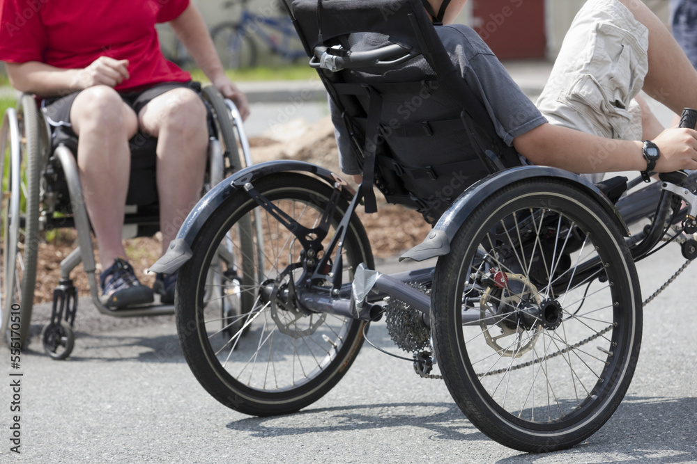 Boy with tendonitis on bike and a woman with degenerative hip in a wheelchair
