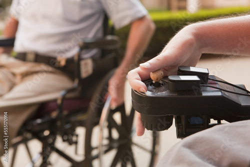 Man with Duchenne muscular dystrophy controlling a motorized wheelchair with degenerated hands photo