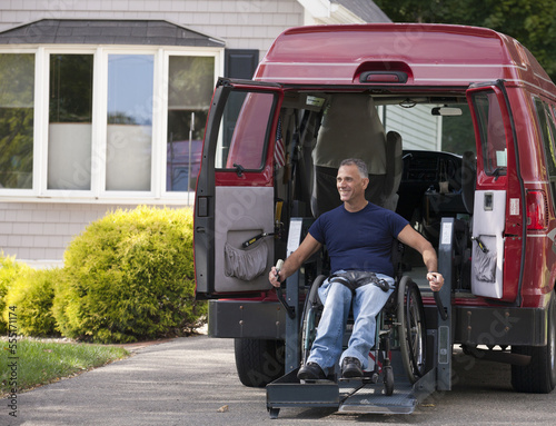 Man with spinal cord injury in a wheelchair getting in his accessible van photo