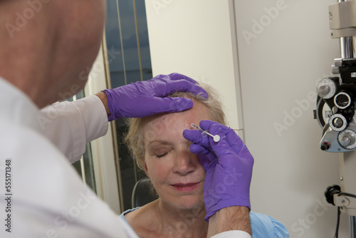 Ophthalmologist giving a Botox injection to a patient photo