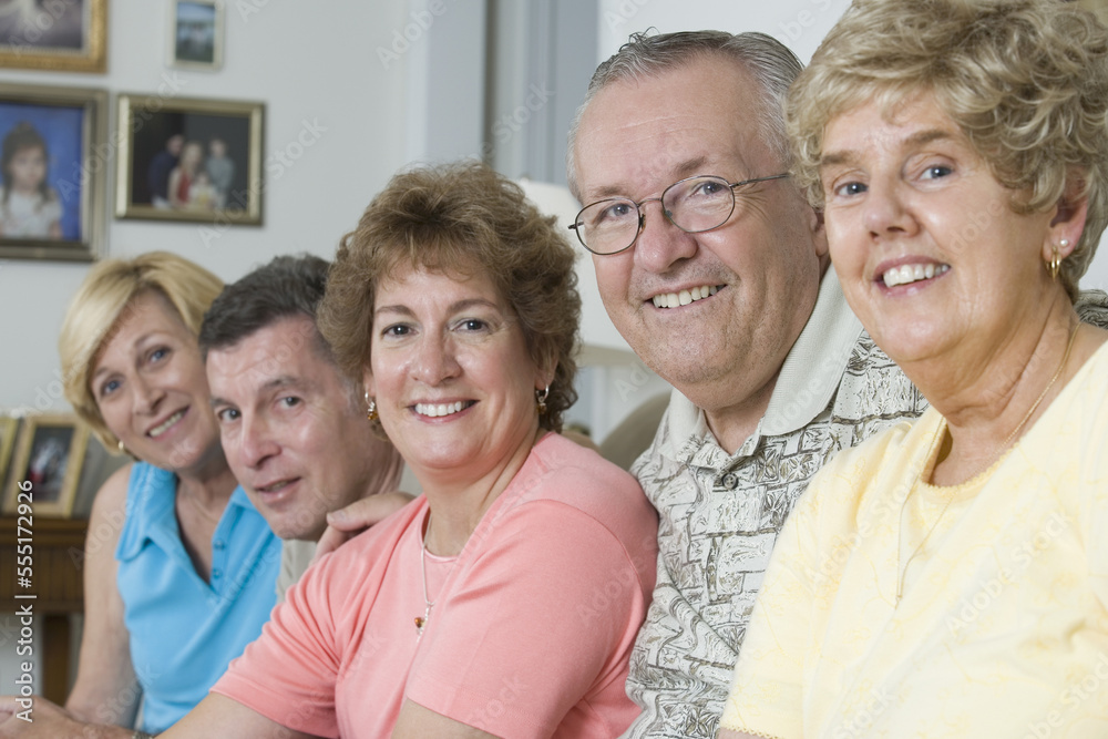 Group of seniors smiling together in a home Group of seniors smiling together in a home