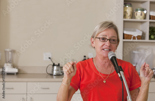 Senior female announcer making an announcement at luncheon photo