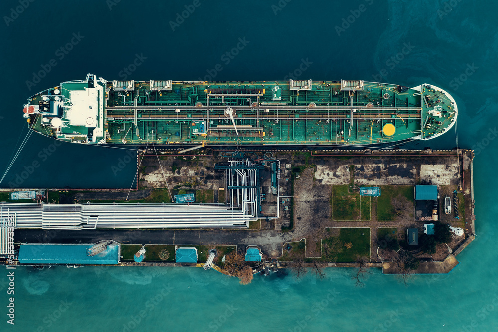Oil tanker ship in industrial port aerial top view, logistic and transportation oil and gas industry.