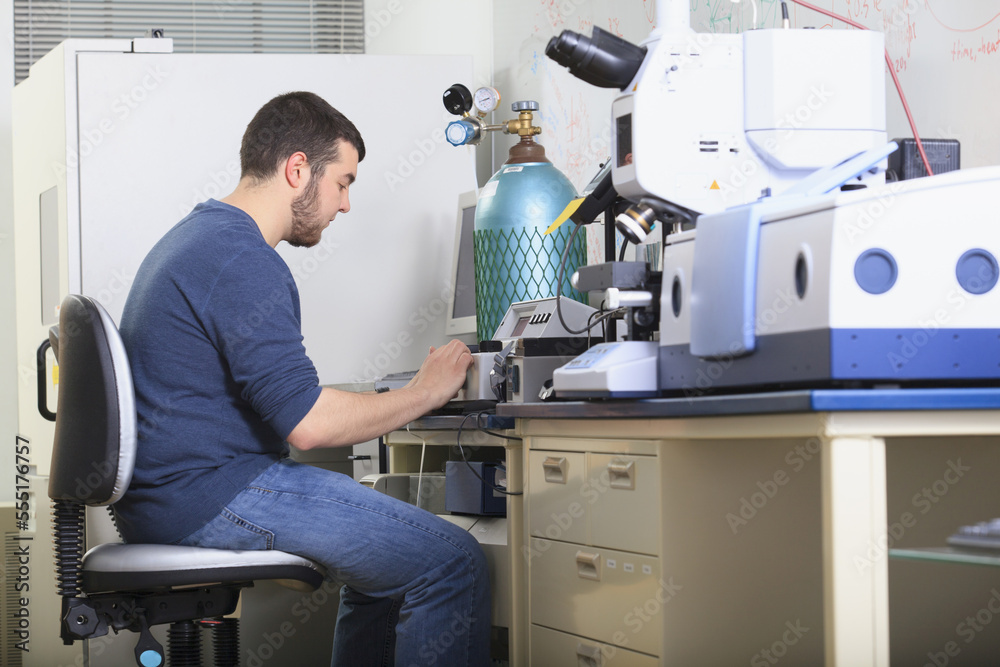 Engineering student reading the screen of chemical analysis equipment in a laboratory Engineering student reading the screen of chemical analysis equipment in a laboratory