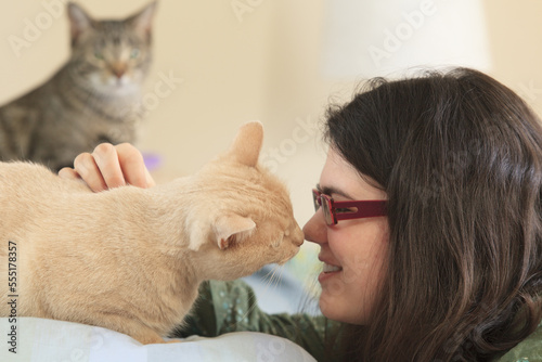 Woman with Asperger syndrome playing with her pet cats photo