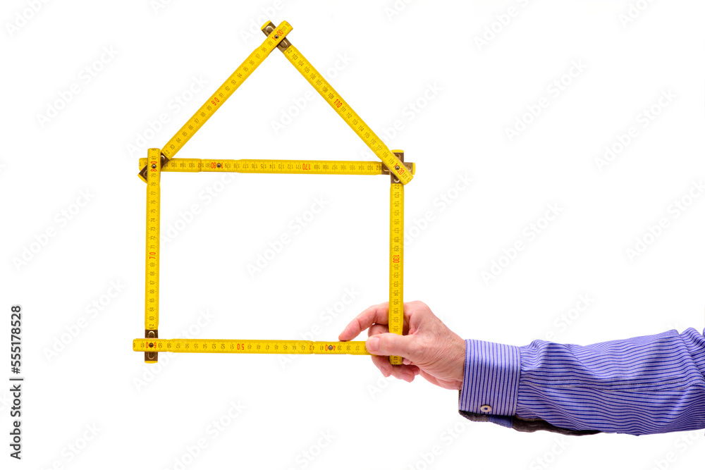symbol of a newly built house shaped with meter rule in hand symbol of a newly built house shaped with meter rule in hand