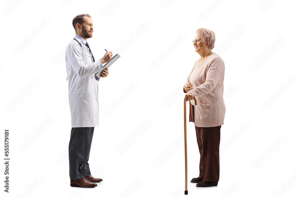 Full length profile shot of a doctor writing a document and standing with an elderly female patient