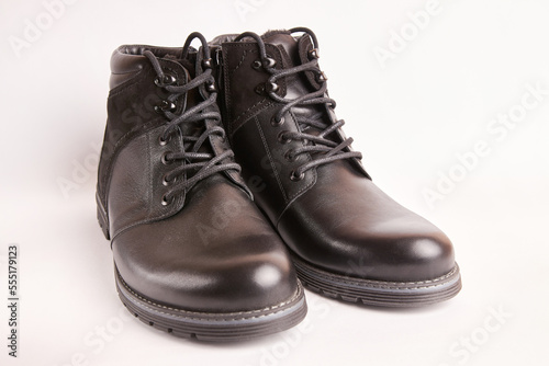 Black leather men's boots on a white background. Warm shoes for winter. © Vasyl
