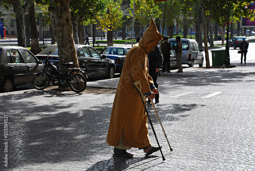 Hombre anciano paseando con muletas. photo