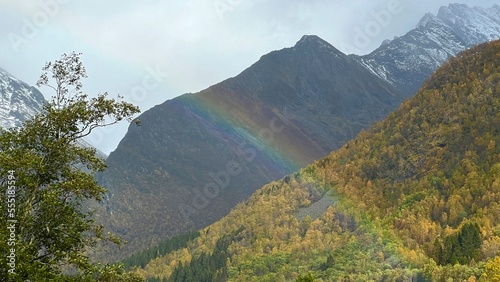 Colorful rainbows across the mountains among autumn foliage in Norway