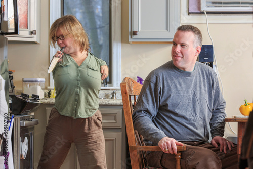 Woman with TAR Syndrome picking up a knife with her husband in the kitchen photo