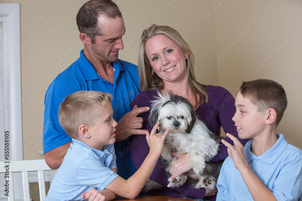 Family with hearing impairments sitting around a table describing 'Love' in American Sign Language Family with hearing impairments sitting around a table describing 'Love' in American Sign Language