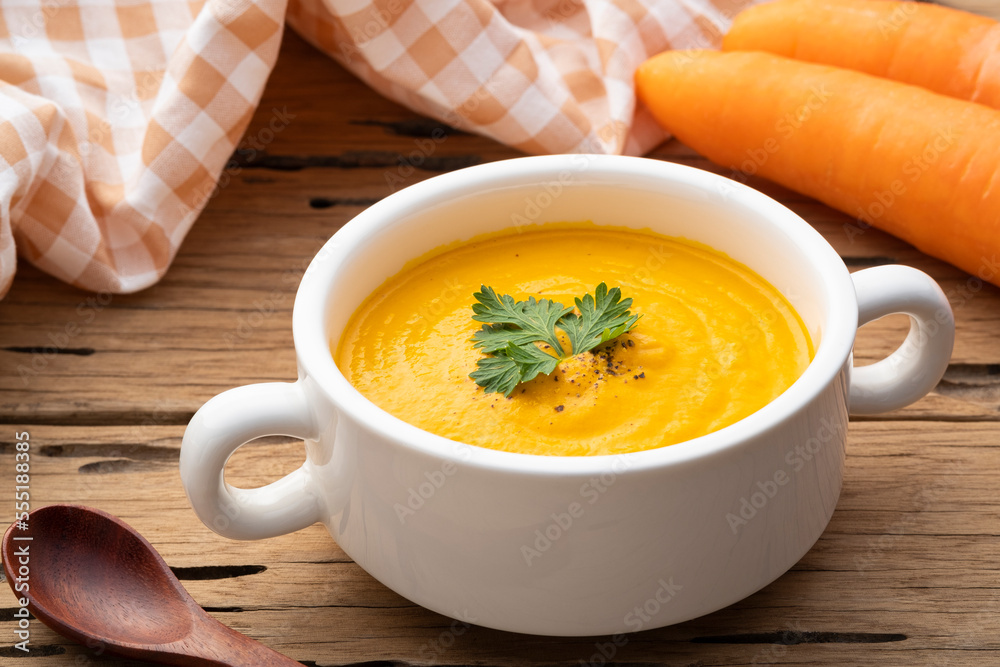 Bowl of tasty Creamy Carrot Soup with vegetables on wooden table,Healthy food Bowl of tasty Creamy Carrot Soup with vegetables on wooden table,Healthy food