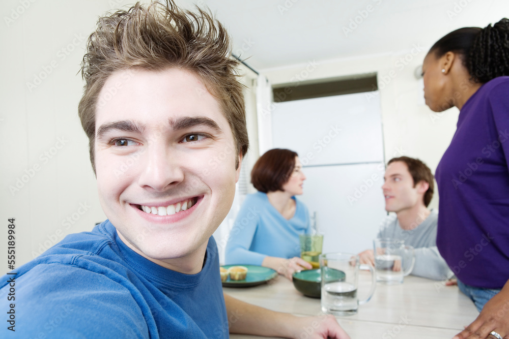 Close up of a young man with friends in background. Close up of a young man with friends in background.