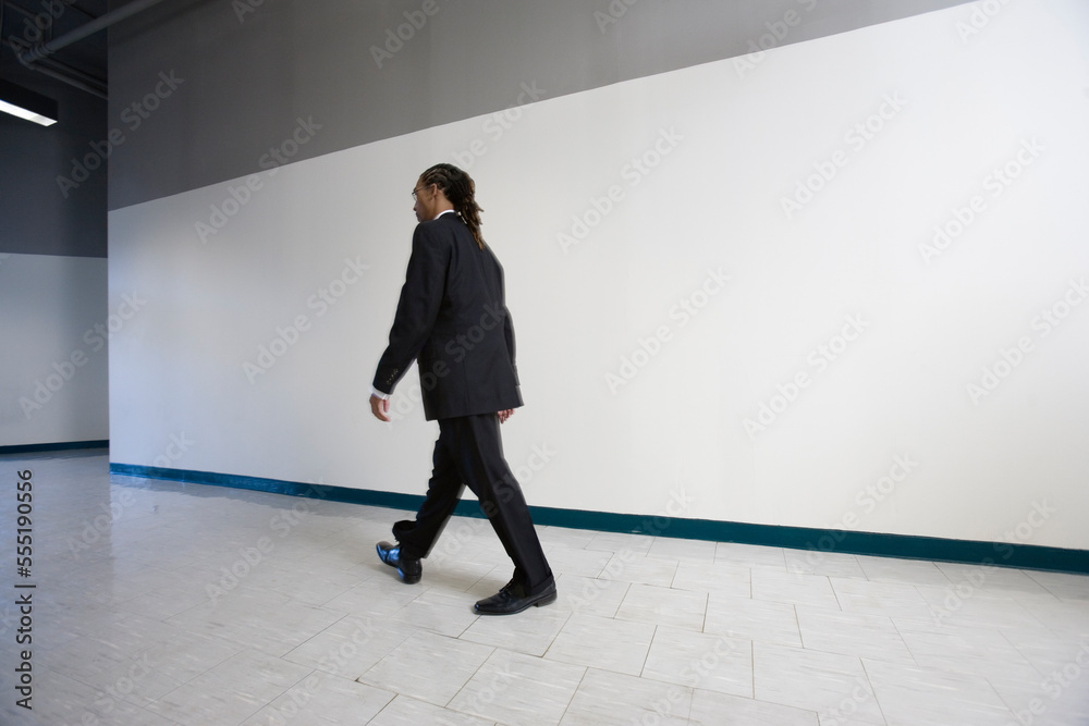 A young man walking in the corridor. A young man walking in the corridor.