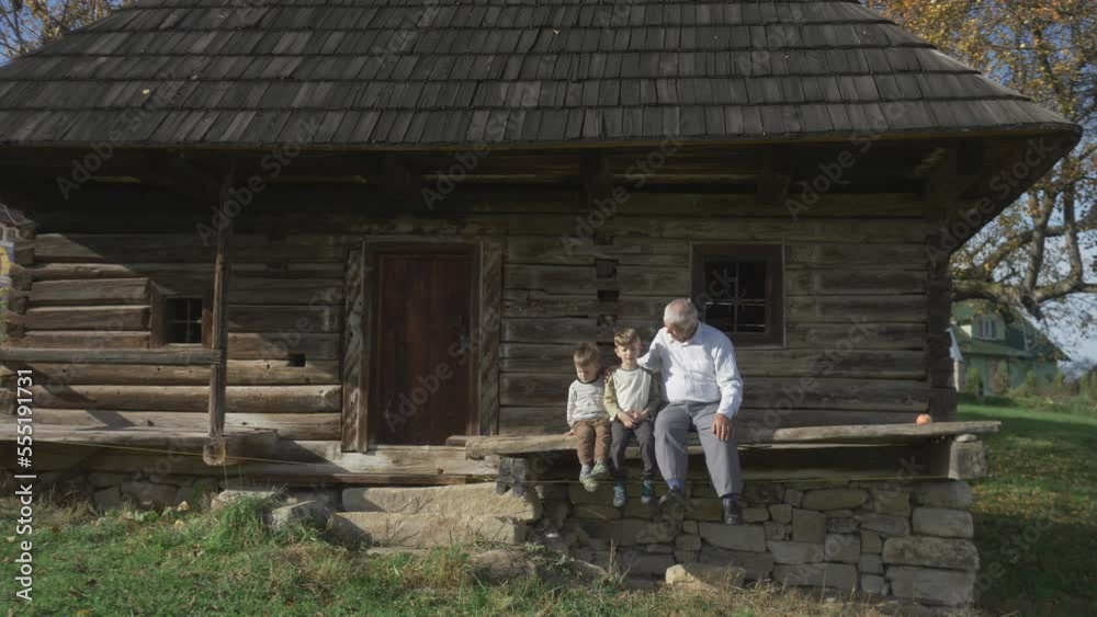 Grandchildren enjoy time with their grandfather on the porch of the rural house Grandchildren enjoy time with their grandfather on the porch of the rural house