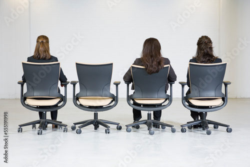 Rear view of business women sitting on office chairs. photo