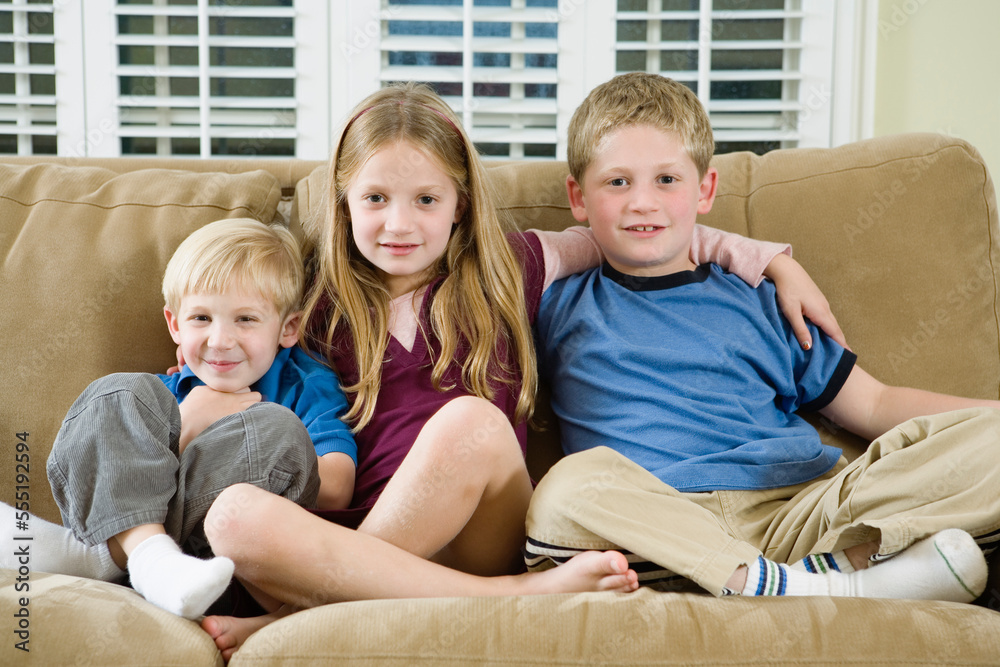 Portrait of three children sitting on a sofa. Portrait of three children sitting on a sofa.
