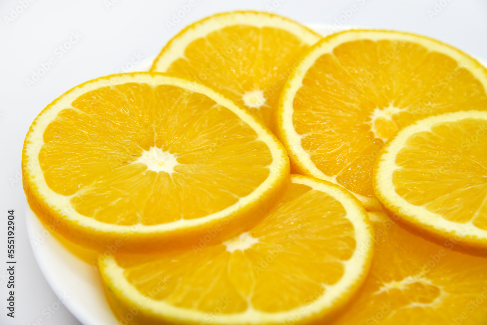 Sliced orange slices on a white plate. Orange slices on a white background. Oranges close-up. Sliced orange slices on a white plate. Orange slices on a white background. Oranges close-up.