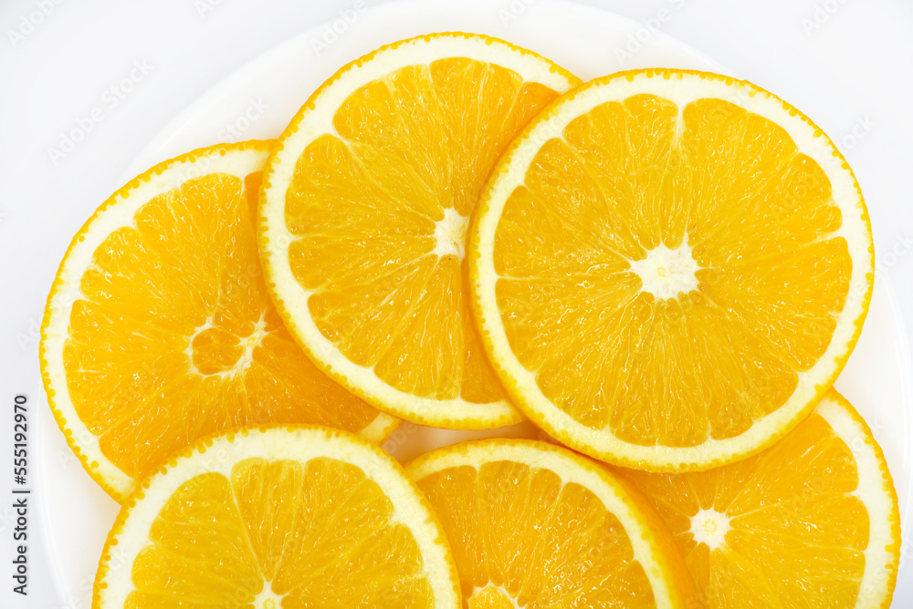 Sliced orange slices on a white plate. Orange slices on a white background. Oranges close-up. Sliced orange slices on a white plate. Orange slices on a white background. Oranges close-up.