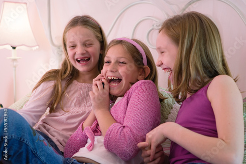 View of three cute girls smiling.