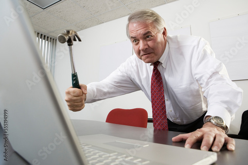 View of a business man trying to hit a laptop. photo