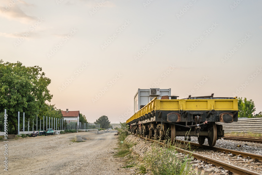 Empty working freight car on railway tracks. Concrete sleepers for the installation of a new railway through the town of Petrovaradin. Vojvodina, Novi Sad, Serbia.