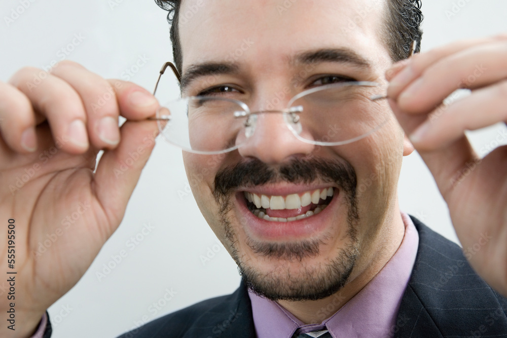 Portrait of a businessman holding eyeglasses and smiling Portrait of a businessman holding eyeglasses and smiling