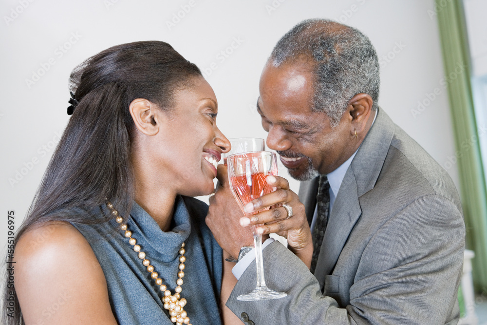 Close-up of a middle-aged couple toasting with wine glasses and smiling Close-up of a middle-aged couple toasting with wine glasses and smiling
