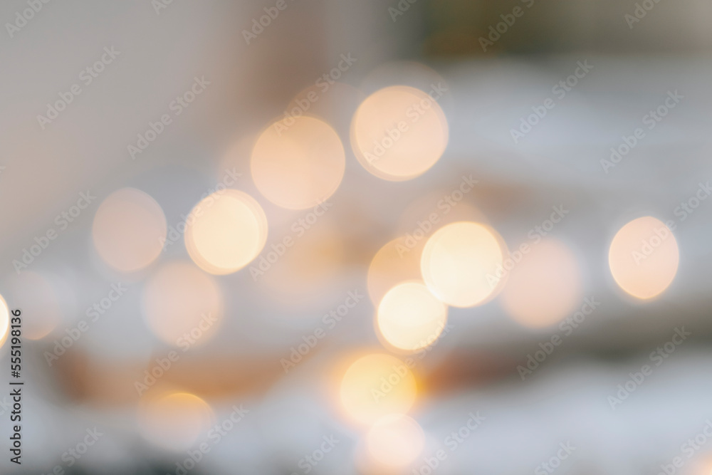 Yellow bokeh effect on a light background. Bokeh background from a garland. Abstract Blurred Christmas Lights Bokeh Background