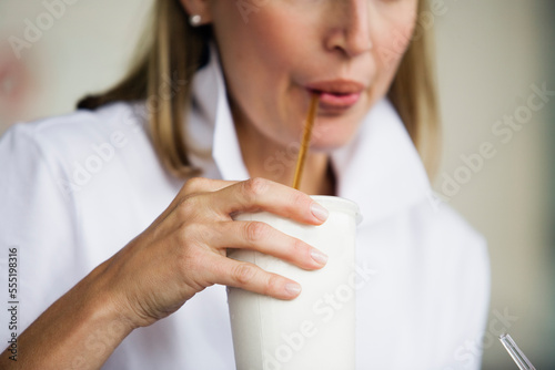 View of a woman drinking milkshake.