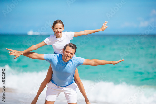 Family of dad and daughter have fun together on the beach