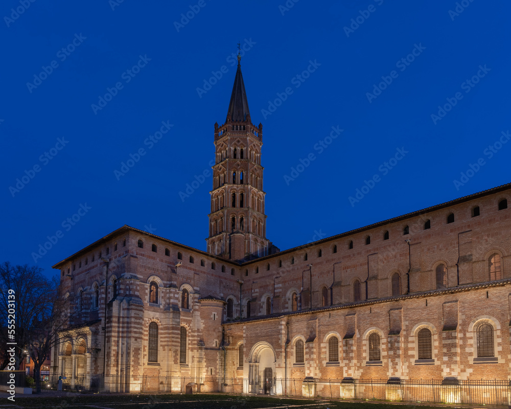 Scenic landscape view of historic landmark St Sernin basilica illuminated in evening, Toulouse, France