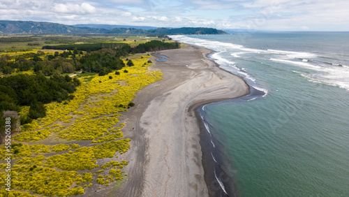Aerial shot of the point where the river Tolten flows into the pacific ocean in Araucania, Chile  photo