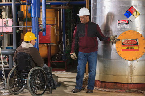 Power Plant engineers one with spinal cord injury discussing demineralization process equipment photo