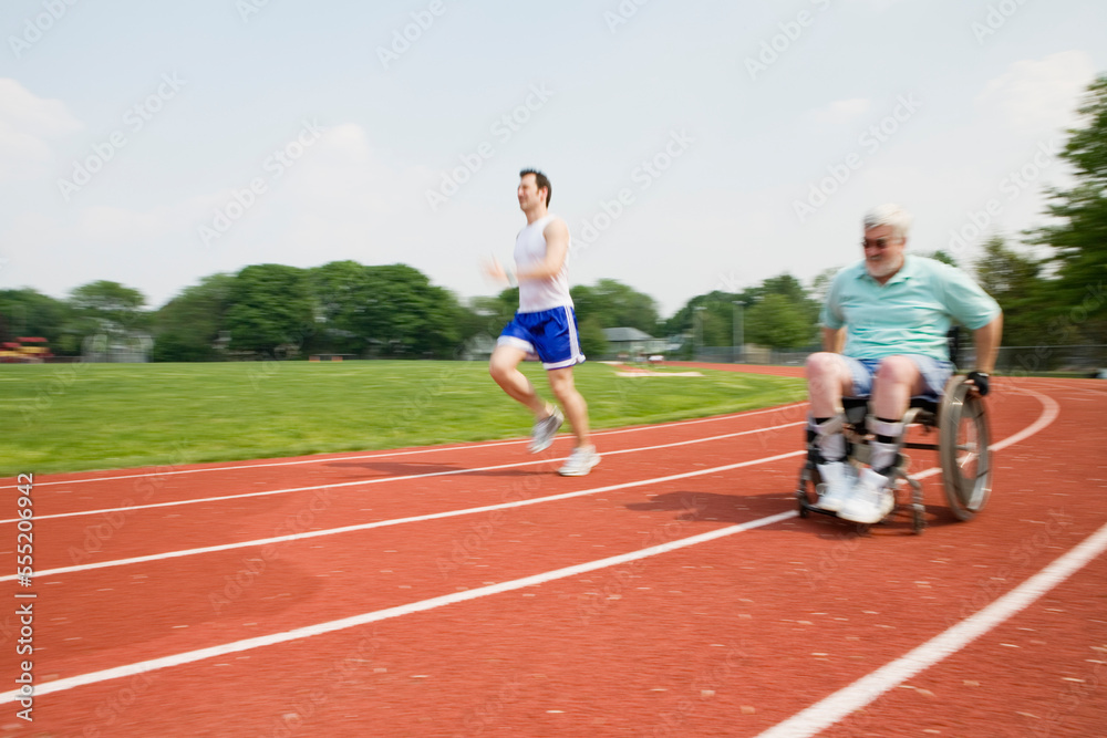 Young man racing with a handicapped senior man on a racetrack. Young man racing with a handicapped senior man on a racetrack.