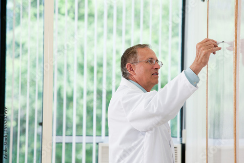 Professor at whiteboard during lecture photo