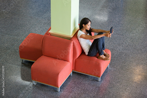 Engineering student reading a digital tablet in student lounge photo