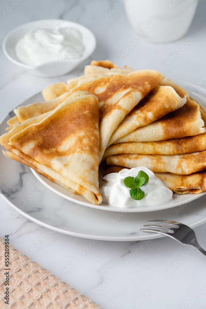 Stack of russian thin pancakes blini with fresh sour cream Stack of russian thin pancakes blini with fresh sour cream