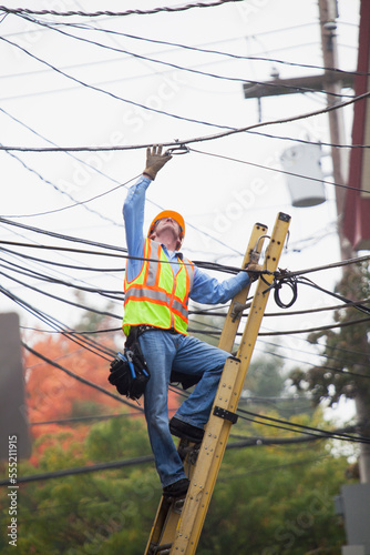 Wallpaper Mural Cable lineman assessing cable splice in the city from ladder Torontodigital.ca