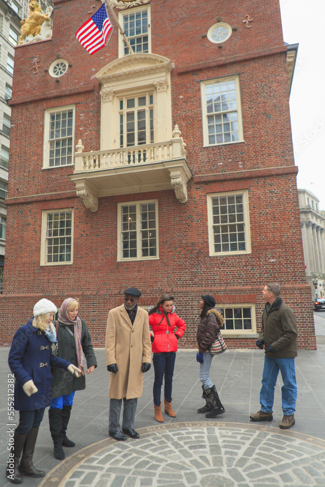 Tourists in front of The Old State House and looking at The Boston Massacre Historic Site, Boston, Suffolk County, Massachusetts, USA Tourists in front of The Old State House and looking at The Boston Massacre Historic Site, Boston, Suffolk County, Massachusetts, USA