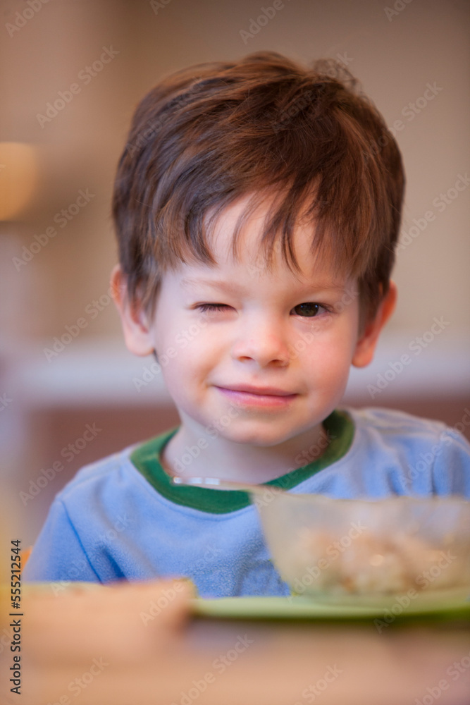 Little boy sitting at a breakfast table with a bowl of cereal Little boy sitting at a breakfast table with a bowl of cereal
